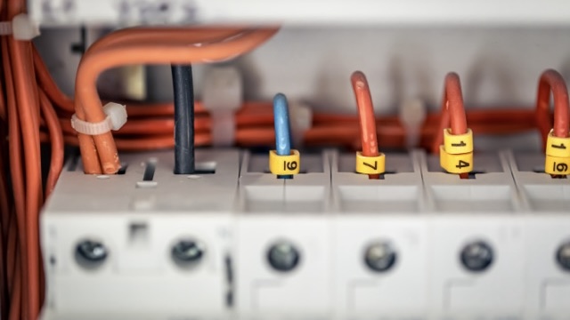 Close up circuit breakers and wire in control panel.